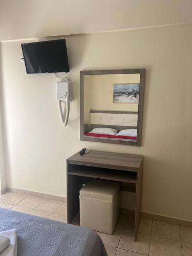 a bedroom with a mirror and a desk with a bed at SimOtel Ermis in Hanioti