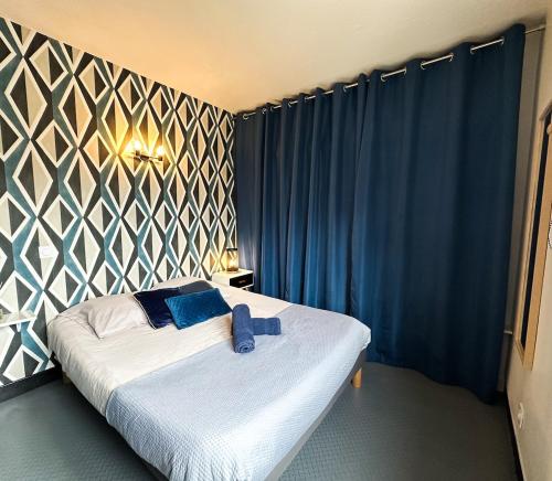 a bedroom with a bed with blue towels on it at Appartement Spacieux T1bis - Centre-ville in Agen