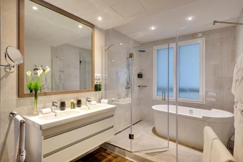 a bathroom with a sink and a tub and a shower at Melia Madrid Serrano in Madrid