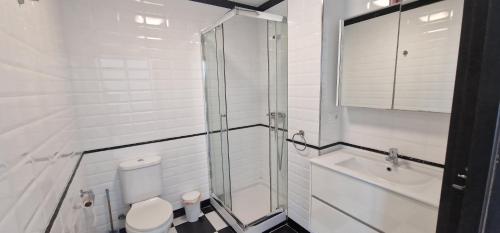 a bathroom with a shower and a toilet and a sink at Villa Llevant in Miami Platja