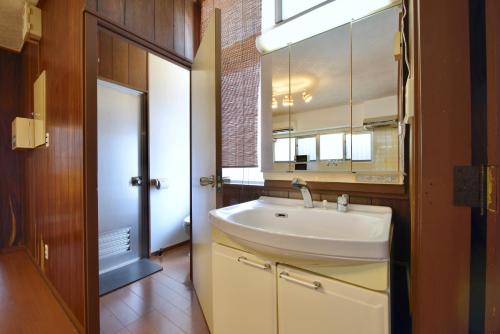 a bathroom with a sink and a mirror at Mensore Houese in Naha