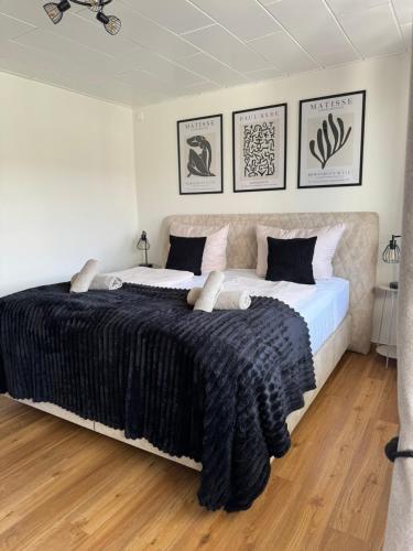 a bedroom with a large bed with a black blanket at RheinLoft Apartment - Balkon & Parkplatz "optional" am Deutschen Eck in Koblenz