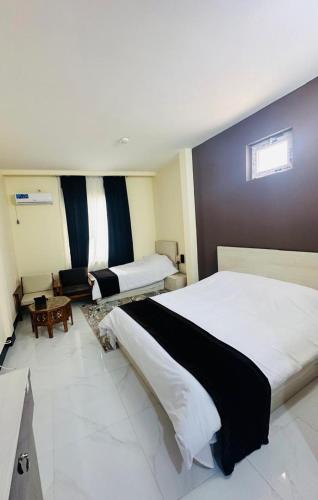 a hotel room with a large bed and a couch at Herat Star Hotel in Herāt