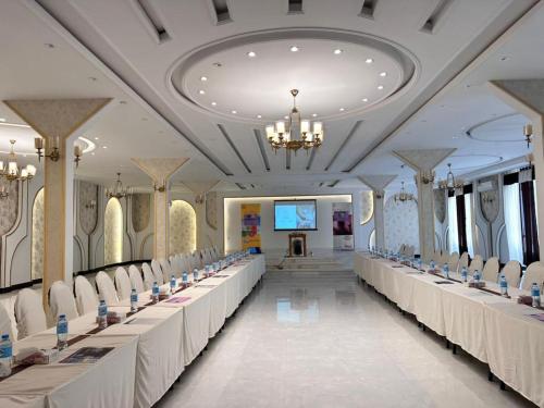 a large banquet hall with white tables and chairs at Herat Star Hotel in Herāt