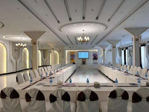 a conference room with tables and chairs and a screen at Herat Star Hotel in Herāt