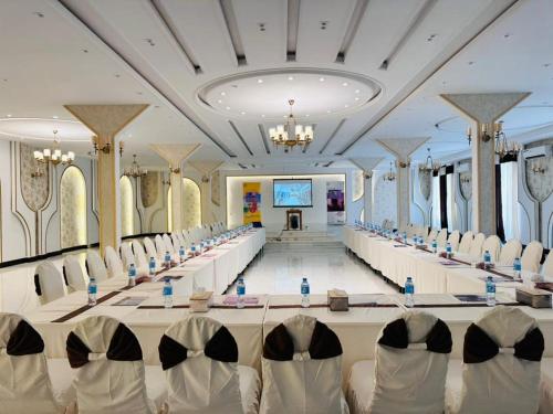 a long banquet hall with white chairs and a stage at Herat Star Hotel in Herāt