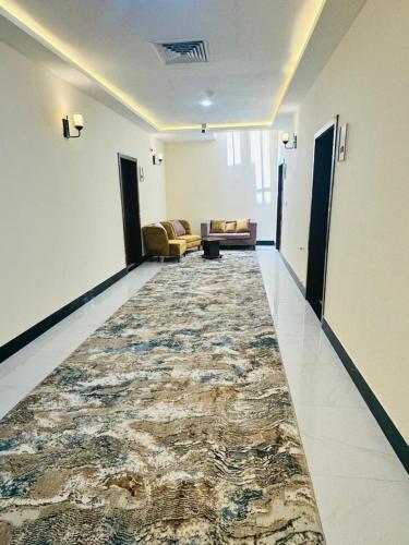 a hallway with a large rug in a room with a couch at Herat Star Hotel in Herāt