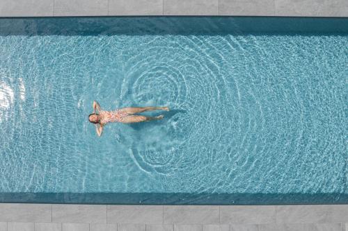 a man is swimming in a swimming pool at Alpenwellnesshotel St. Veit in Sesto