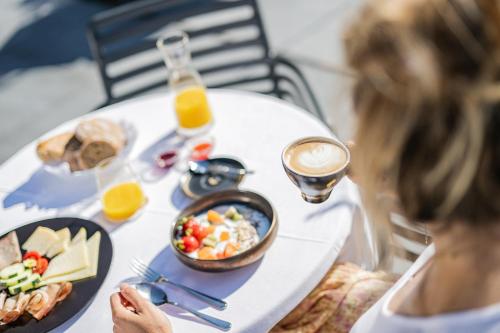 a woman sitting at a table with a plate of food at Alpenwellnesshotel St. Veit in Sesto