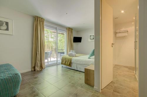 a bedroom with a bed and a sliding glass door at Le Cottage - Hotel & Spa in Argelès-sur-Mer