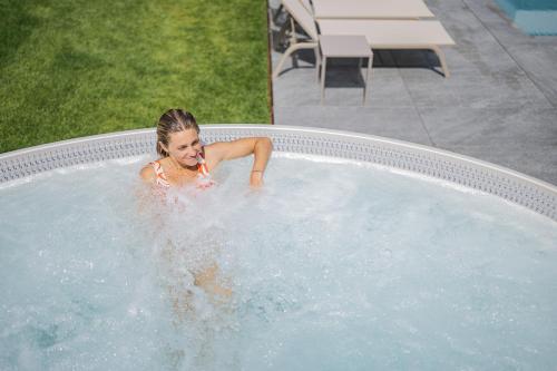 a woman in a jacuzzi in a pool at Alpenwellnesshotel St. Veit in Sesto
