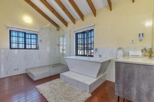 a large bathroom with a tub and a sink at Summit Della Suite in Centurion
