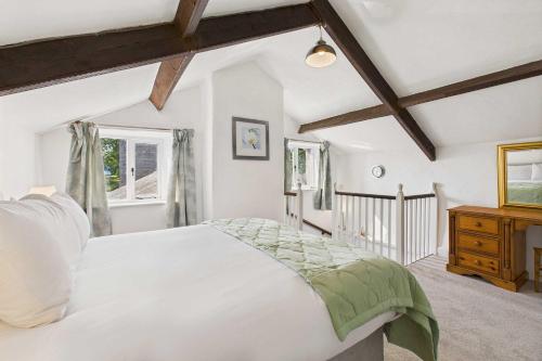 a bedroom with a white bed and a wooden dresser at Host & Stay - Brackenrigg Cottage in Rothbury