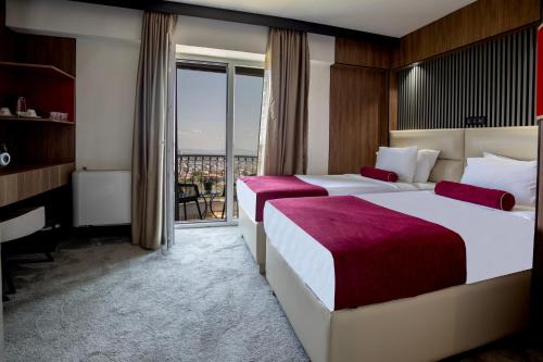 a hotel room with two beds and a balcony at View Inn Boutique Hotel in Skopje