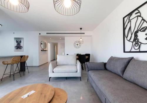 a living room with a couch and a table at O&O Group - Luxury APT/3 BR/New Tower/Parking in Or Yehuda