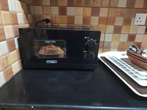 a toaster oven with a pan of food in it at Aspire Lodge, G11 Islamabad - A Family Guest House & Hotel in Islamabad