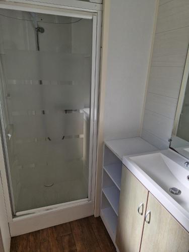 a bathroom with a glass shower and a sink at Camping Onlycamp Les Chênes Verts in Cabrières-dʼAigues