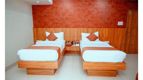 a room with two beds and a red wall at Hotel DC Star in Tarapith