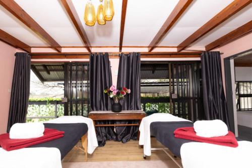 a room with two beds and a table with flowers at Summit Della Suite in Centurion