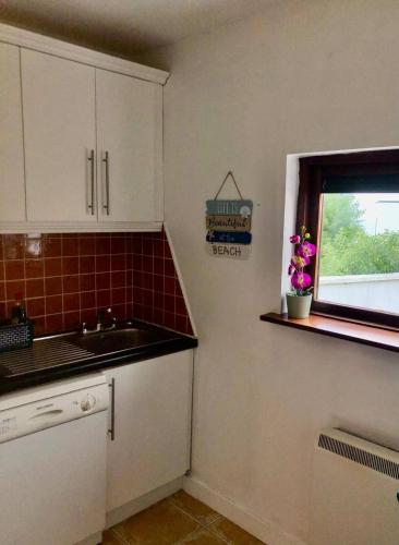 a kitchen with a sink and a window at Bayview Villa Costal Retreat in Youghal