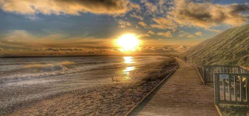 a sunset on a beach with the sun setting at Bayview Villa Costal Retreat in Youghal