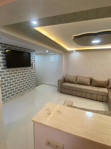 a living room with a couch and a flat screen tv at Résidence Assalam - en bord de mer in Azla