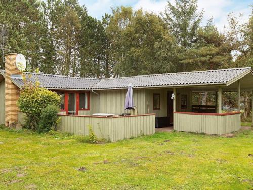 een klein huis met een hek in een tuin bij 6 person holiday home in Rødby in Rødby