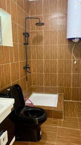 a bathroom with a black toilet and a shower at Chez Pauline in Sainte Marie
