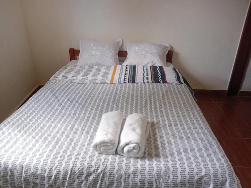 a bed with two towels on top of it at Chez Pauline in Sainte Marie