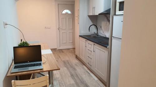 a kitchen with a laptop computer on a wooden table at Vallgorguina Uno in Vallgorguina