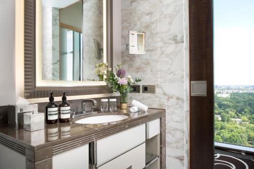 a bathroom with a sink with wine bottles on it at Waldorf Astoria Berlin in Berlin