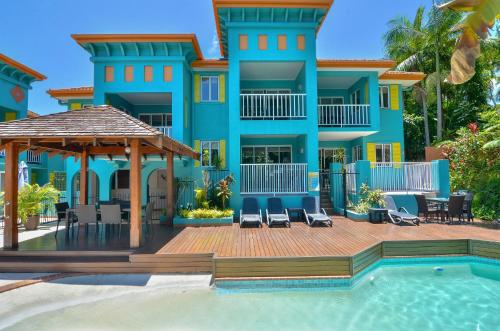 a villa with a swimming pool and a house at Azzurra on Macrossan Adults only Apartment in Port Douglas