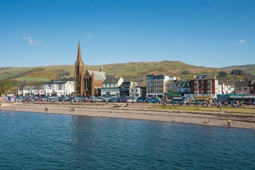 a group of people on a beach next to the water at Largs seaside retreat in Largs