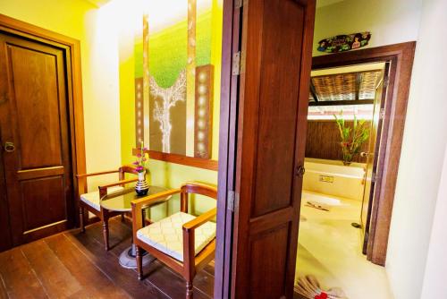 a room with a table and chairs and a door at Sibsan Resort & Spa Maetaeng Chiang Mai in Mae Taeng