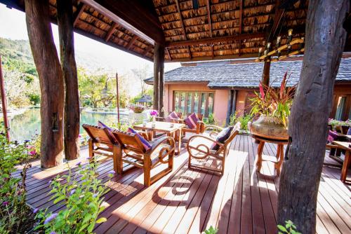 a wooden deck with chairs and a table on it at Sibsan Resort & Spa Maetaeng Chiang Mai in Mae Taeng