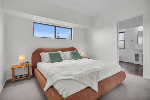 a bedroom with a large bed with two green pillows at Saltwater Apartments in Eden