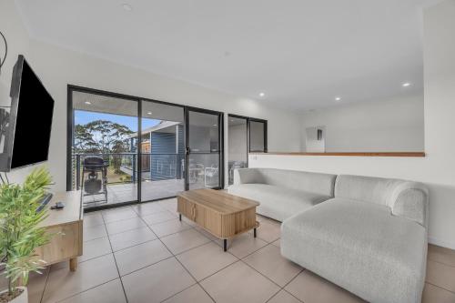 a living room with a couch and a table at Saltwater Apartments in Eden