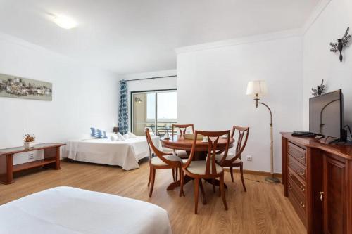 a hotel room with a table and chairs and a bed at Blife Vitorya private apartment in Faro