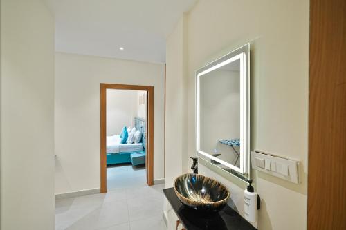 a bathroom with a sink and a mirror at Shreshtam Apart Hotel, Gachibowli in Hyderabad