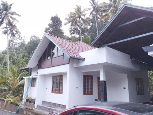 a white house with a red roof at Highrange Retreat in Idukki