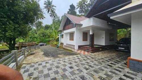 a house with a car parked in front of it at Highrange Retreat in Idukki