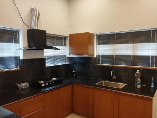 a kitchen with a black counter top and wooden cabinets at Highrange Retreat in Idukki