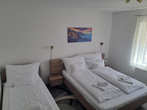 two beds sitting next to each other in a bedroom at Vár-Völgye Vendégház in Csesznek