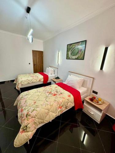 a hotel room with two beds and a table at The Hotel Syracuse in Casablanca