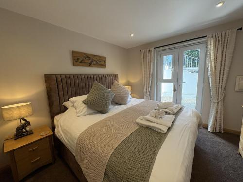 a bedroom with a bed with towels on it at Mi Casa Su Casa - Mount Brioni in Downderry