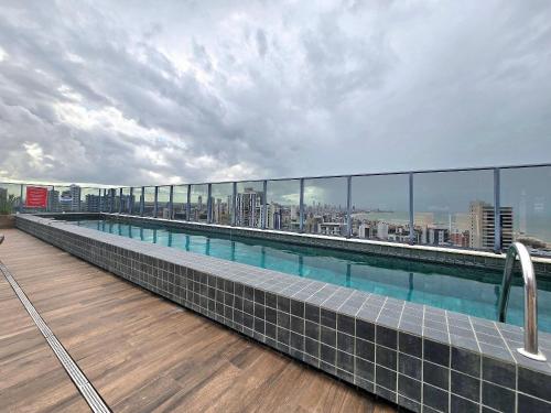 a swimming pool on the roof of a building at One Way by Hosppedar in Tambaú