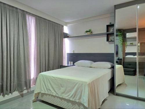 a bedroom with a bed and a large window at One Way by Hosppedar in Tambaú