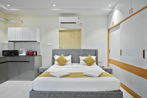 a bedroom with a large bed with yellow pillows at Shreshtam Apart Hotel, Gachibowli in Hyderabad
