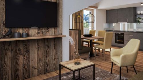 a living room with a television and a dining room at Die Monika Aparthotel in Gaschurn