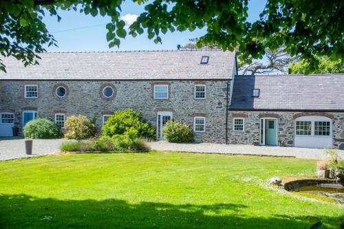 an old stone house with a grass yard at The Stables in Holyhead